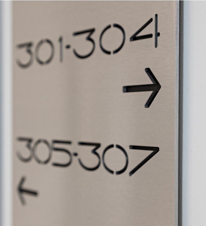 Línea de señalización de metal con caracteres estarcidos y soporte de plexiglas
